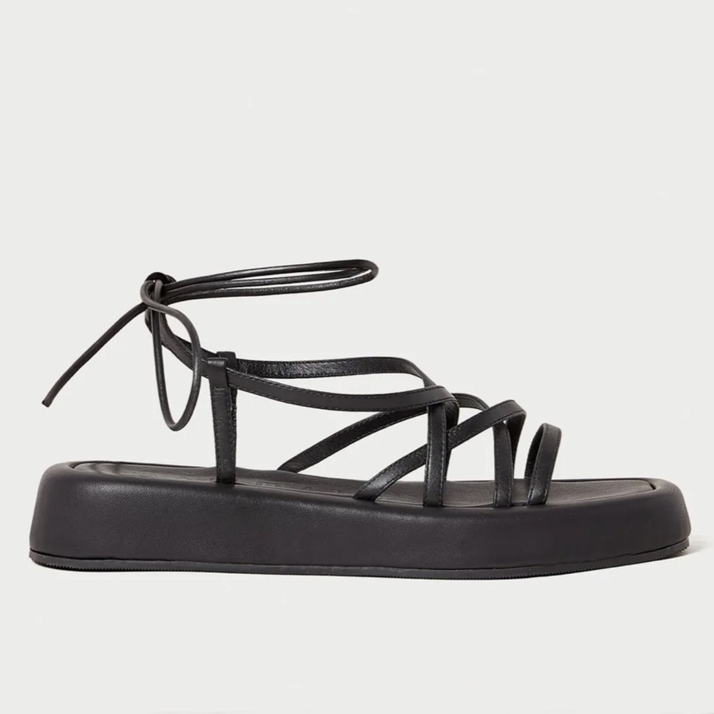 Chunky platform sandal w crisscross straps in black leather. 1.25” platform